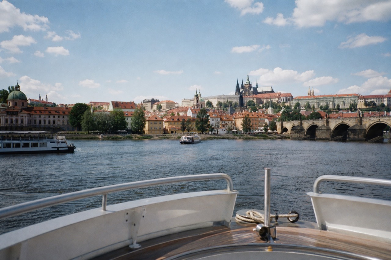 Prague Castle and St Vitus Cathedral on the hill above the Vltava, with a sightseeing boat passing below