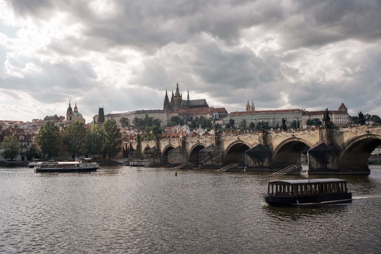 Prague Castle, St Vitus Cathedral and Charles Bridge over the Vltava seen together from a boat at dusk